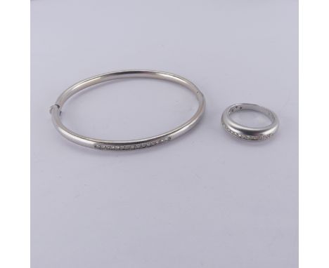 An 18ct white gold hinged Bangle, the front channel set with fifteen small diamonds, 5.7cm internal width, together with a co