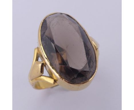 A smoky quartz Ring, the oval facetted stone approx. 17.4mm long, collect set in unmarked yellow gold, tested as 18ct, Size K