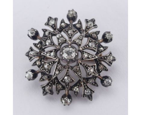 A late Victorian diamond snowflake Brooch, with old cut and rose cut diamonds, the centre stone approx. 0.25ct, unmarked, ass