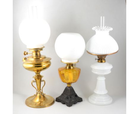 Oil lamp, brass base, with chimney and opaque shade, 61cm; an opaque glass table lamp with chimney and shade; and a cast iron