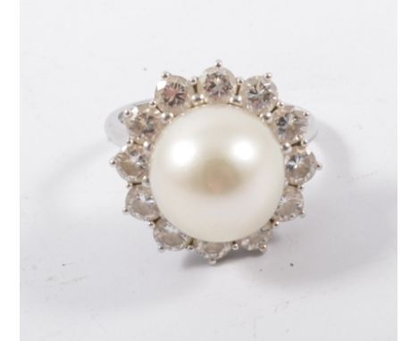 A diamond and pearl ring, a 12.3mm cultured pearl peg set and surrounded by twelve brilliant cut diamonds in an all white met