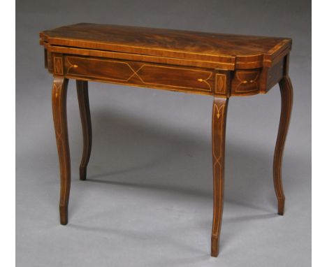 A George III mahogany inlaid card table, early 19th century, the shaped rectangular folding top, upon inlaid freize, raised o