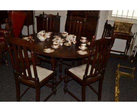 An early 20th century oak gate leg drop leaf dining table;  a set of six accompanying dining chairs, drop in seats, c.1920