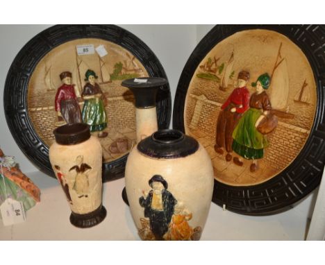 A pair of Bretby Zudyer Zee circular plaques, moulded in low relief with traditional Dutch figures in National dress, beside 