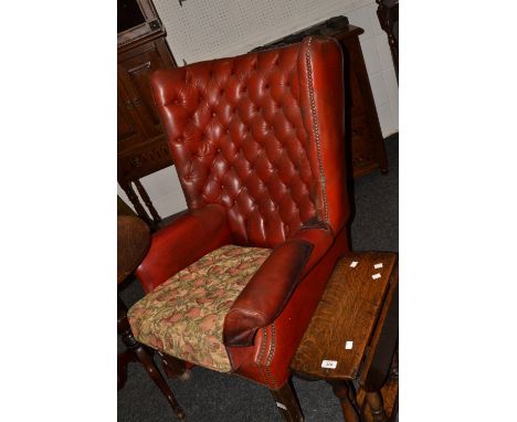 A leather wingback armchair, button back upholstery in red, square mahogany legs