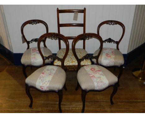 A set of four mahogany balloon back chairs, having carved frets, upholstered in a floral and pin-striped fabric, raised on ca