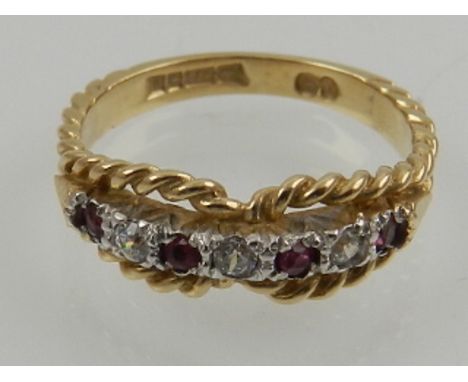 A 9 carat yellow gold, diamond, and ruby ring, the stones set within a rope twist mount. 