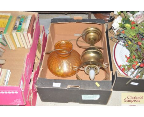 A box containing a brass oil lamp converted to electricity with glass shade