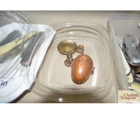 A Victorian yellow metal egg shaped sovereign holder on chain; a Victorian perfume flask and a gilt miniature basket of eggs 