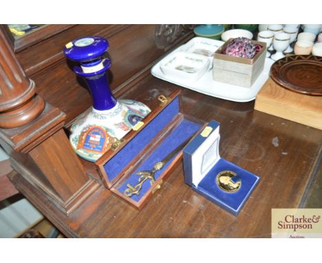 A Nelson mint coin; and a boxed brass paper knife; and a HMS Victory Trafalgar decanter and stopper 