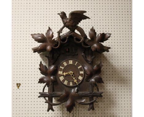 A BLACK FOREST THREE TRAIN DOUBLE CUCKOO WALL CLOCK, having three belows, the chalet style case with applied vine leaves and 
