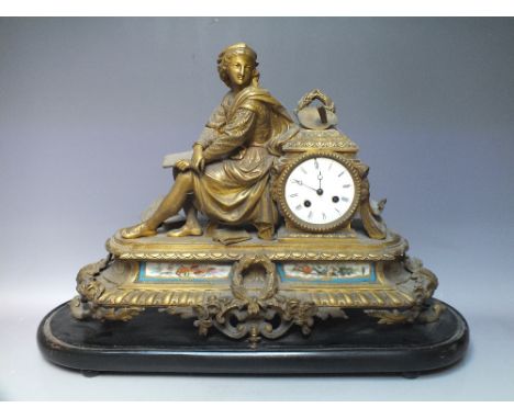 A FRENCH GILT FIGURAL MANTLE CLOCK, the enamel dial with Roman numerals, the cast metal case with inset ceramic panels to the