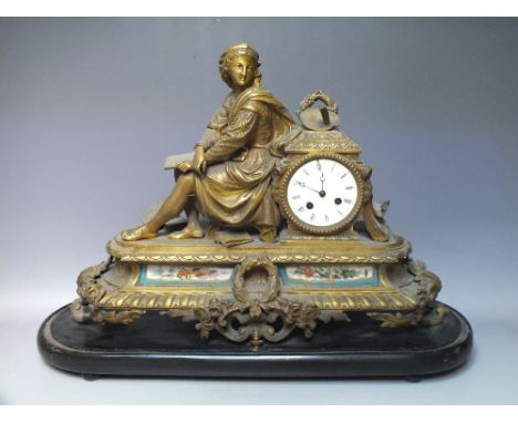 A FRENCH GILT FIGURAL MANTLE CLOCK, the enamel dial with Roman numerals, the cast metal case with inset ceramic panels to the