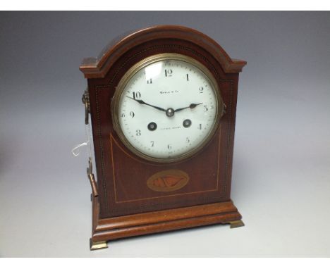 AN EDWARDIAN MAPLE & CO INLAID WOODEN MANTLE CLOCK, the circular enamel dial with Arabic numerals, the eight day movement sta