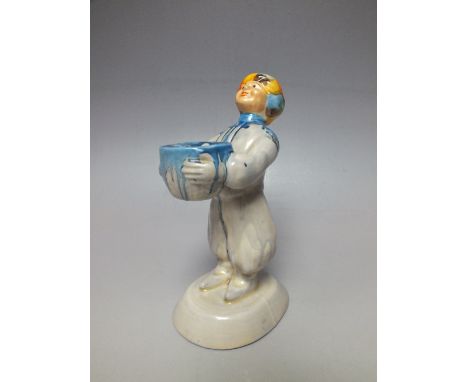 A CLARICE CLIFF STYLE 'ARAB BOY' FIGURAL CANDLESTICK, modelled as figure in turban carrying a basket, raised on an oval plint