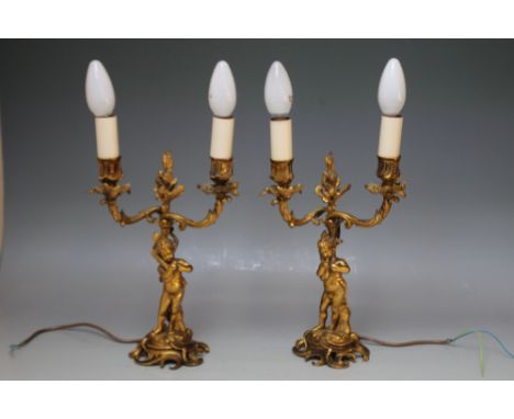 A PAIR OF GILT METAL TWO BRANCH CANDELABRA, with cherubic detail, converted to electric use, height of centre point 26.5 cm