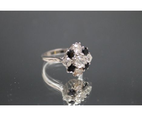 AN 18 CT WHITE GOLD SAPPHIRE AND DIAMOND RING, the central old cut diamond being approx 0.60 carat with a further two at appr