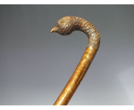 A VINTAGE FOLK ART WALKING STICK, the pommel carved in the form of a partridge head, having inset glass eyes, L 103.5 cm