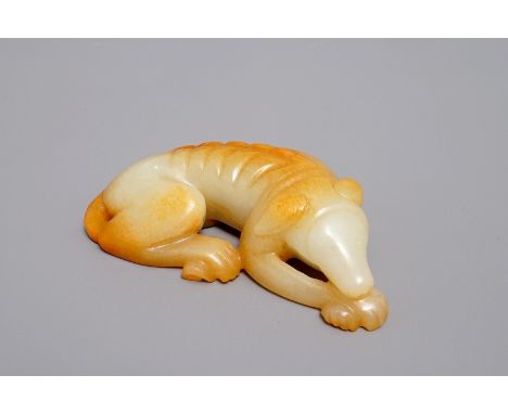 A Chinese carved russet jade model of a reclining dog, 19/20th C. H.: 2,5 cm - L.: 8,5 cm We have more lots available exclusi