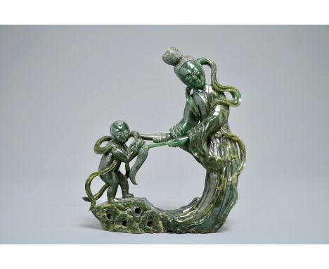 A Chinese spinach green jade group of Guanyin with a child, 19th C. H.: 22,5 cm - L.: 20,5 cm We have more lots available exc