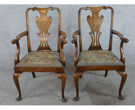 A pair of 20th century mahogany framed open arm chairs with pierced splat backs raised on cabriole supports terminating in pa