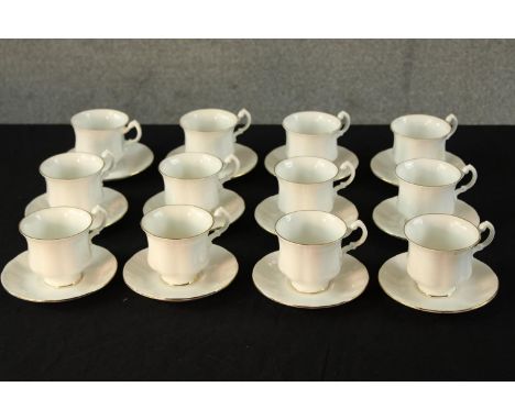 Twelve 20th century Royal Standard white painted porcelain cups and saucers, each with gold painted rims. H.8 Dia.12cm. 