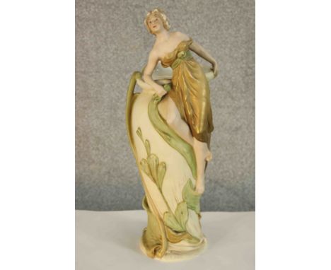 An Art Nouveau (early 20th century) Royal Dux porcelain figural vase, moulded with a classical maiden surmounting a floral va