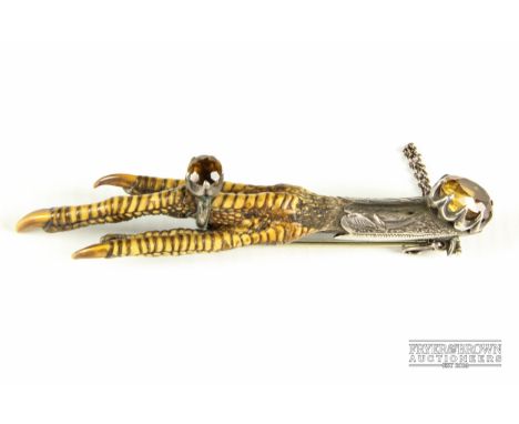 A Victorian chicken's foot brooch, mounted in white metal with stone, one claw with a ring with matching stone, 9cm long 