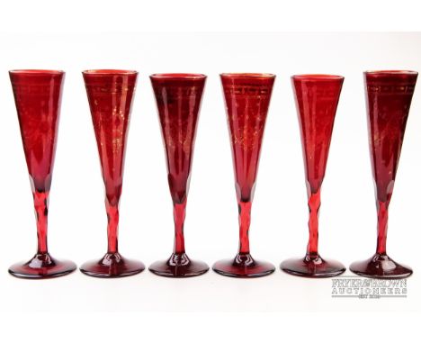 Six Bohemian ruby glass flutes, with faceted stems, gilded with neoclassical swags, c1830 (6)