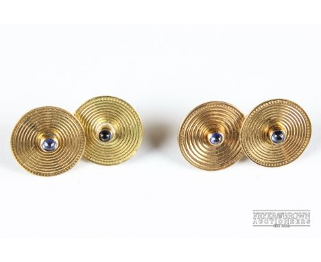 An attractive pair of Art Deco gold and sapphire cufflinks, composed of round grooved yellow gold discs with cabochon sapphir