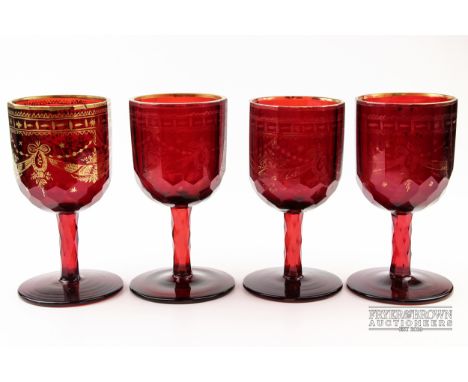 Four large Bohemian ruby glass goblets, with faceted bowls and stems, the bowls gilded with neoclassical swags, c1830, 17cm h
