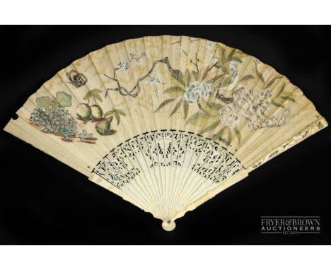 An 18th century ladies fan, the ivory sticks with cut-out decoration of an urn flanked by ladies and men playing lutes amongs