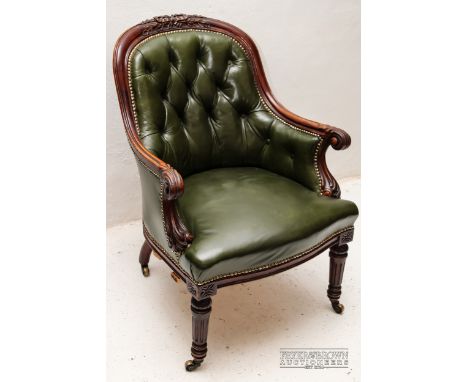 A mahogany and green leather button back armchair, carved detail to wood frame and stud detailing to upholstery