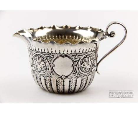 A silver cream jug, repousse decorated with floral motifs, wavy rim, makers mark for James Dixon & Son, Sheffield 1891, 44grs