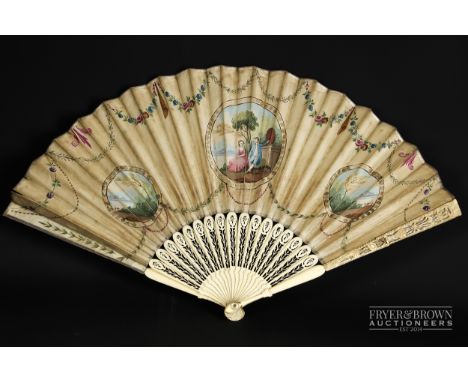 An 18th century ladies fan, the ivory sticks very delicately carved with ornate cut out decoration, the guards further decora