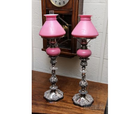A pair of old Sheffield plate candlesticks c1850, with later pink glass oil lamp containers and pink glass shades (2)