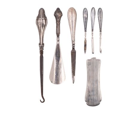 A group of silver-handled dressing / grooming tools, including a shoehorn, a button hook, nail files, etc, together with a si