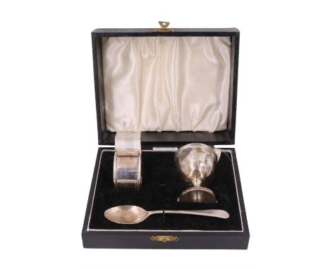 A cased silver Christening set, comprising napkin ring, pedestal egg-cup and matching Old English pattern spoon, all free fro