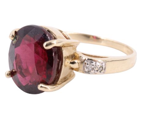 A contemporary rhodolite and diamond finger ring, having a 4.7 carat oval garnet prong set between open arched shoulders, eac