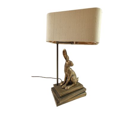 A late 20th Century bronzed resin table lamp modelled as a hare sitting on books, 50 cm