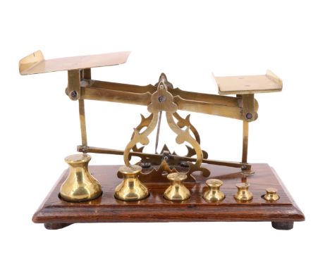A set of early 20th Century brass and oak postal balance scales and weights, 24 x 14 x 14 cm (two smallest weights later)