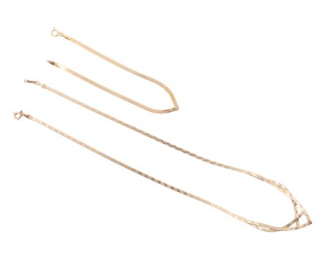 A 1980s 9 ct gold ribbon necklace, the front forming an open chevron and having engine turned surface decoration, together wi