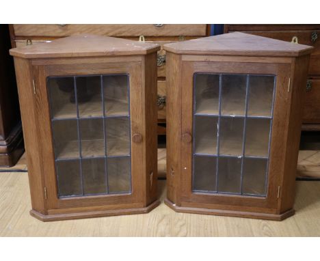 A pair of diminutive leaded glazed oak hanging corner cabinets by Derek 'Lizardman' Slater of Crayke, North Yorkshire, 68 cm[