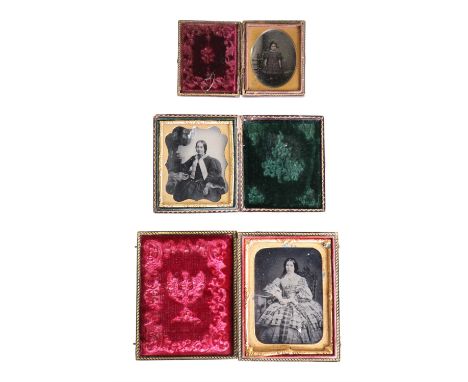 Three Victorian ambrotype photographs respectively portraying two women and a child, two being tinted, in presentation cases,