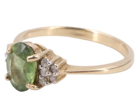 A contemporary peridot and white stone finger ring, comprising a central oval stone of approximately one carat set over adors