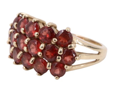 A contemporary Mozambique garnet cluster set ring, having a line of six 3.5 mm brilliants, nestled between two rows of five s