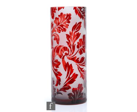 A large later 20th Century glass vase of cylindrical form, cased in ruby over clear crystal and cameo cut with a scrolling ac