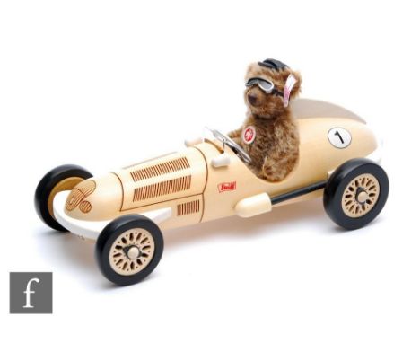 A Steiff 038358 Classic Teddy Bear with Silver Arrow Car, caramel mohair teddy bear wearing cap and driving goggles, height 1