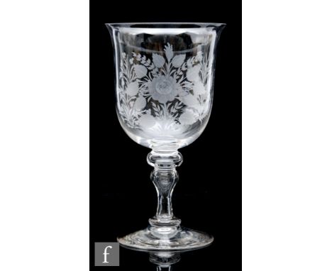 A large late 19th to early 20th Century clear crystal glass goblet, the bell form bowl engraved with emblems, height 23.5cm.&