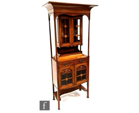 An Art Nouveau mahogany salon display cabinet, with cornice pediment over turned pillar supports a glazed double door cabinet